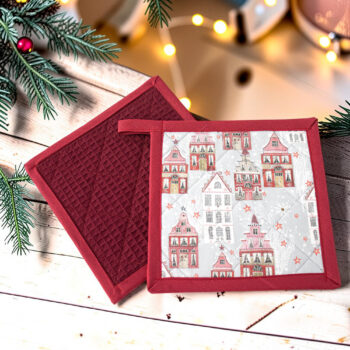 Handgemachte Topflappen mit weihnachtlichem Häuserstoff, rote und weiße Fachwerkhäuser auf hellgrauem Hintergrund mit roten Sternen